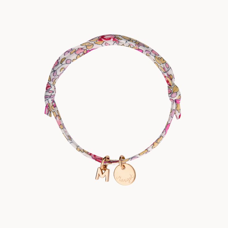 The A-Z of you and me. Build your own alphabet with our Personalized Mini Alphabet Liberty Bracelet by hand-engraving a treasured name or date onto the smooth pastille charm and adding up to 3 delicate letter charms to represent loved ones and little ones. Create a colourful gift by choosing a floral Liberty print to match a special personality18K Champagne Gold Plated and 925 Sterling SilverMini flat disc: 0.4 Diameter, 0.02 ThicknessMini alphabet charm: 0.2Liberty braid with fully adjustable s Personalized Adjustable White Charms, Personalized White Adjustable Charms, Dainty Personalized Charm Bracelets, Dainty Charms Bracelets For Personalized Gift, Dainty Bracelets With Charms For Personalized Gift, Mother's Day Personalized Initials Charm Bracelet, Adjustable Rose Gold Bracelet With Initials, Adjustable Initials Charm Bracelet, Adjustable Initials Charm Bracelet For Everyday