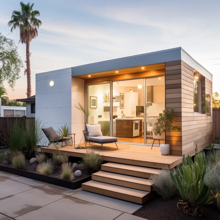 a modern home with wooden steps leading to the front door and patio area at dusk