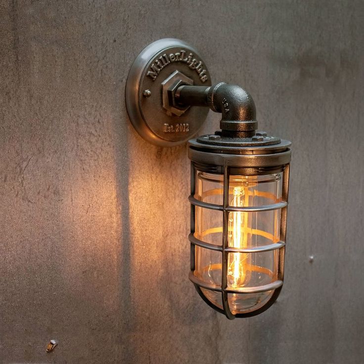 a wall mounted light on the side of a building with an old fashioned bulb attached to it