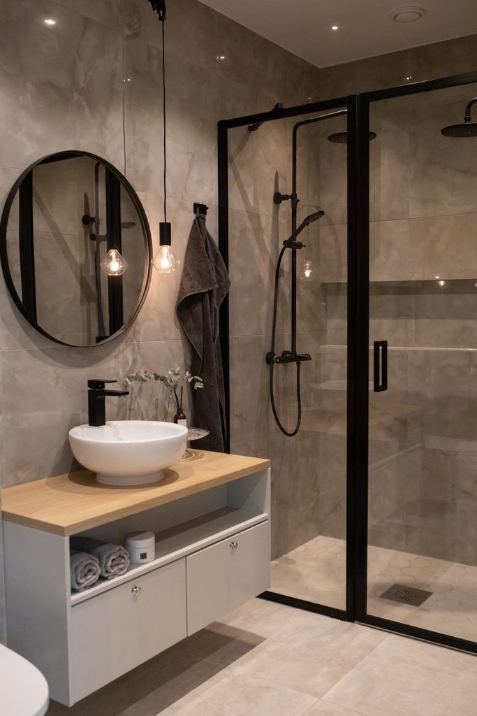 a bathroom with a sink, mirror and shower stall in it's own area