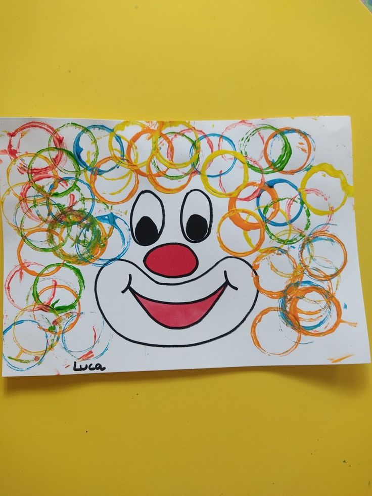 a drawing of a clown with lots of colored rings around it's face on a piece of paper