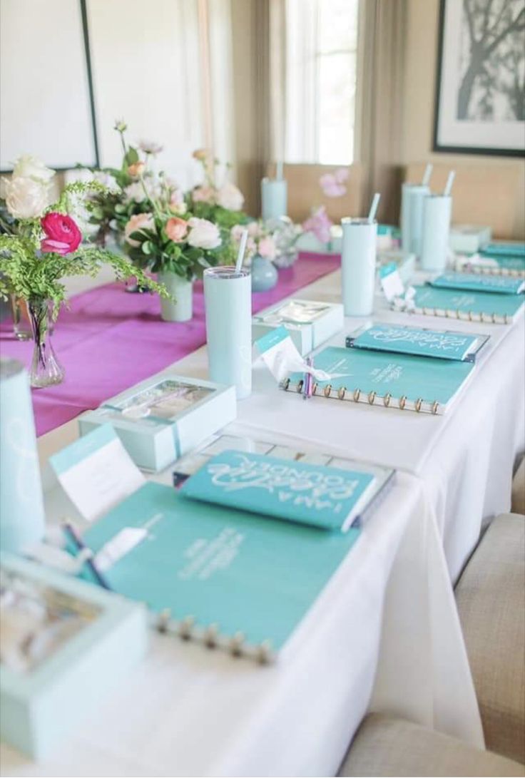 the table is set up with blue and pink place settings for guests to sit at