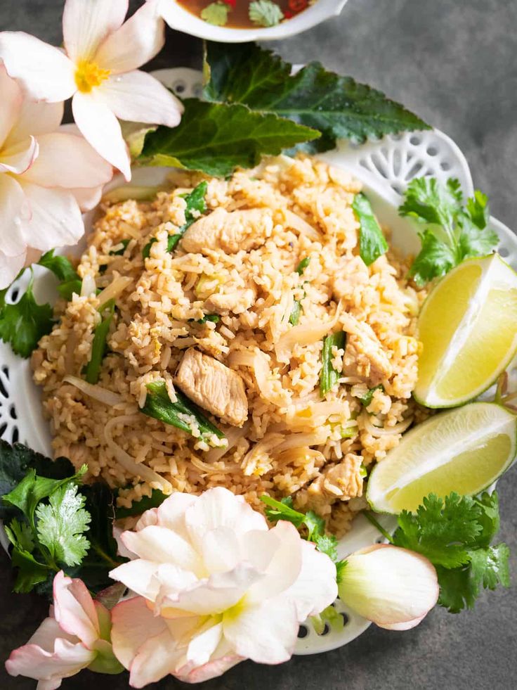 a plate with rice, meat and flowers on it