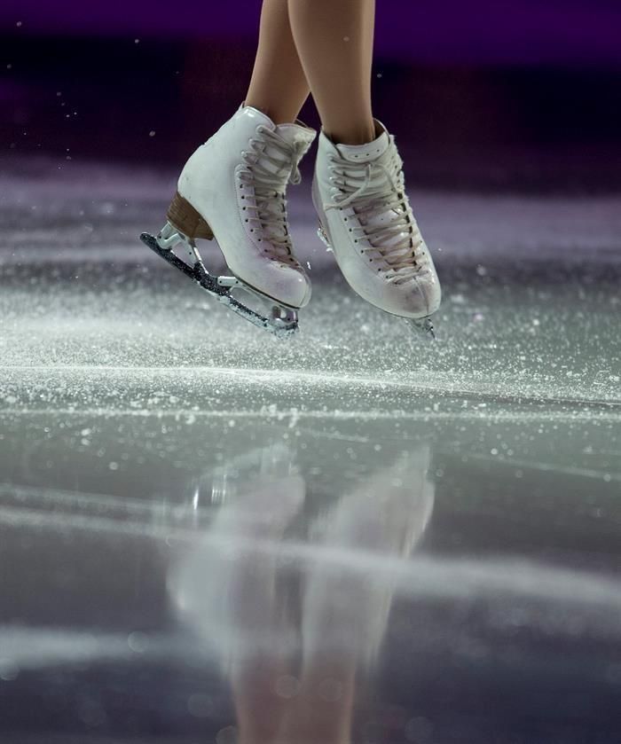 a person in white shoes is skating on ice