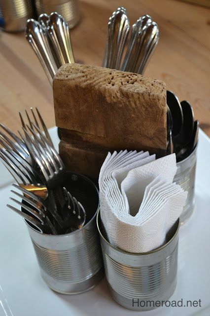 a white plate topped with metal containers filled with utensils