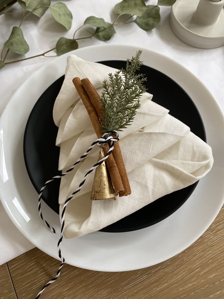 a black and white plate topped with cinnamons and anisette wrapped in twine