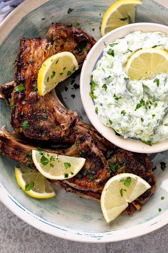 grilled lamb chops with tartar sauce and lemon wedges on the side