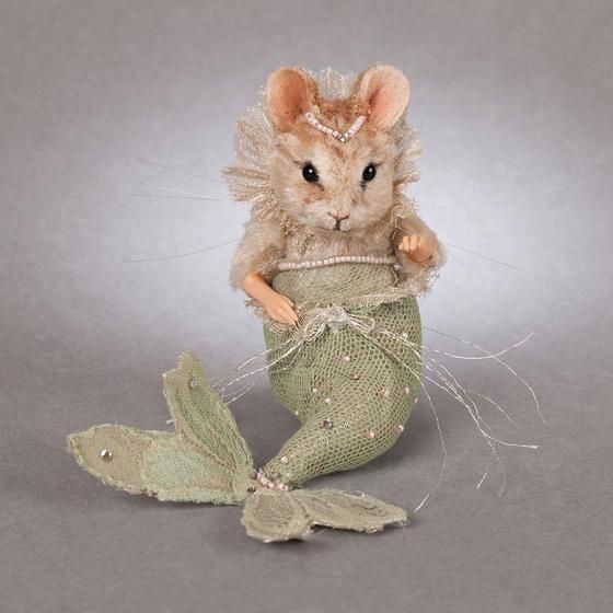 a stuffed mouse is sitting in a green netted bag with a butterfly on it