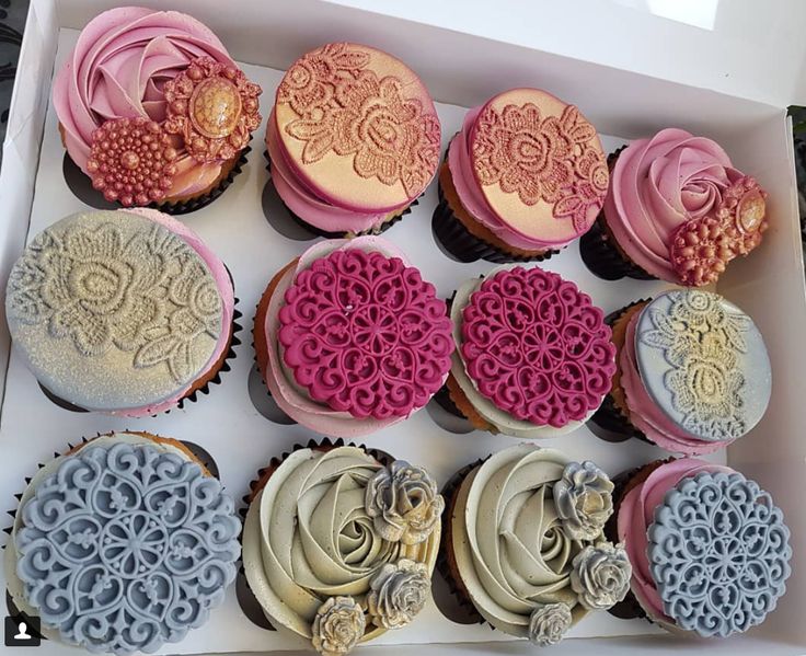 a box filled with lots of different colored cupcakes