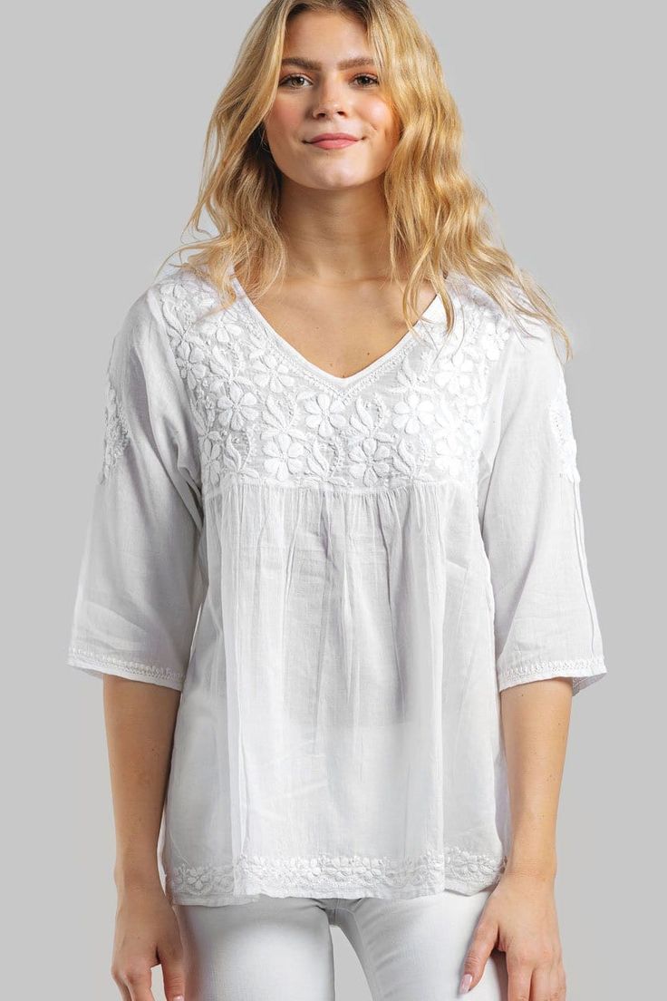 "Our Ramani Embroidered Top is hand embroidered by women artisans in Northern India in the shadow-work style known as \"Chikankari\". Chikankari is a delicate and artfully done hand embroidery that women in this region have been doing for generations. With a comfortable, elegant cut, this tunic is a contemporary twist on the classic Indian kurti and features fine embroidery on the front and back. Sevya's embroidered white kurtis come in a range of uniquely beautiful styles and this tunic is avai White Kurtis, Hand Embroidered Tunics, Embroidered Cotton Top, Indian Kurti, Fine Embroidery, Embroidered Kurti, Fair Trade Clothing, Three Quarter Sleeve Tops, Embroidered Tunic Top