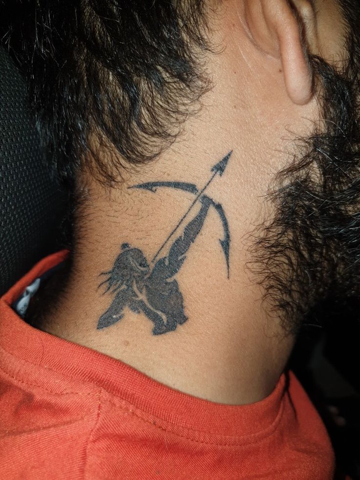 the back of a man's neck with a tattoo on his neck and an arrow