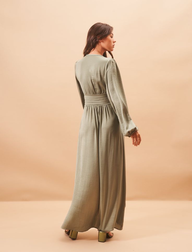 Draped Long Dress in Sage Green Satin

Feminine and bohemian chic, the Elya dress, iconic model of the brand, is perfect for all occasions. 

Crossed neckline embellished with braided details
Balloon sleeves
Draped details at the waist
Curved slot


Cut & Size

Length: 140 cm
The mannequin measures 1.75 m wearing 36
If you hesitate between two sizes, we advise you to choose the upper size for more comfort

Our style advice
Opt for minimalist jewelry and heeled sandals in the tones of your jewelr Fitted V-neck Boho Dress For Party, Elegant Maxi Length V-neck Dress For Brunch, Elegant Ruched Maxi V-neck Dress, V-neck Dress With Smocked Back For Brunch, Fitted Maxi Length V-neck Dress For Daywear, Modest Fitted V-neck Maxi Dress, V-neck Maxi Dress With Elastic Sleeves For Party, Evening V-neck Maxi Dress With Smocked Back, V-neck Dress With Elastic Sleeves For Brunch