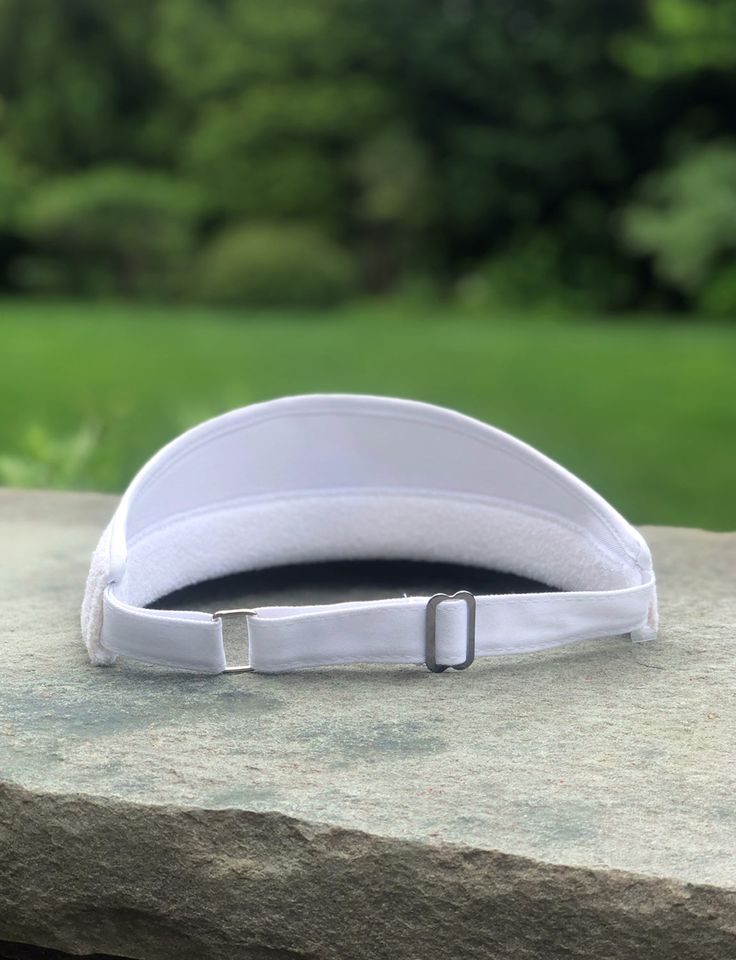 It is rare, in fact very rare, to find a visor made in terry cloth. This high crown style is revered by many and is the perfect accessory on the course or court. Our version has terry trim along the inside. The back has an adjustable metal closure with canvas strap. Unisex visor, adored by both men & women for golf and tennis. Adjustable Sports Visor With Cotton Sweatband, Adjustable Visor With Sweatband For Sports Events, One Size Fits Most Visor With Sweatband, Adjustable White Curved Visor, White Sports Visor, One Size Fits Most, White Sports Visor One Size, Cotton Sweatband Visor One Size Fits Most, Adjustable White Visor For Sports Events, Adjustable White Hat For Tennis