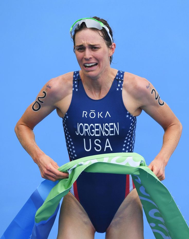 a woman in a blue swimsuit holding a green ribbon