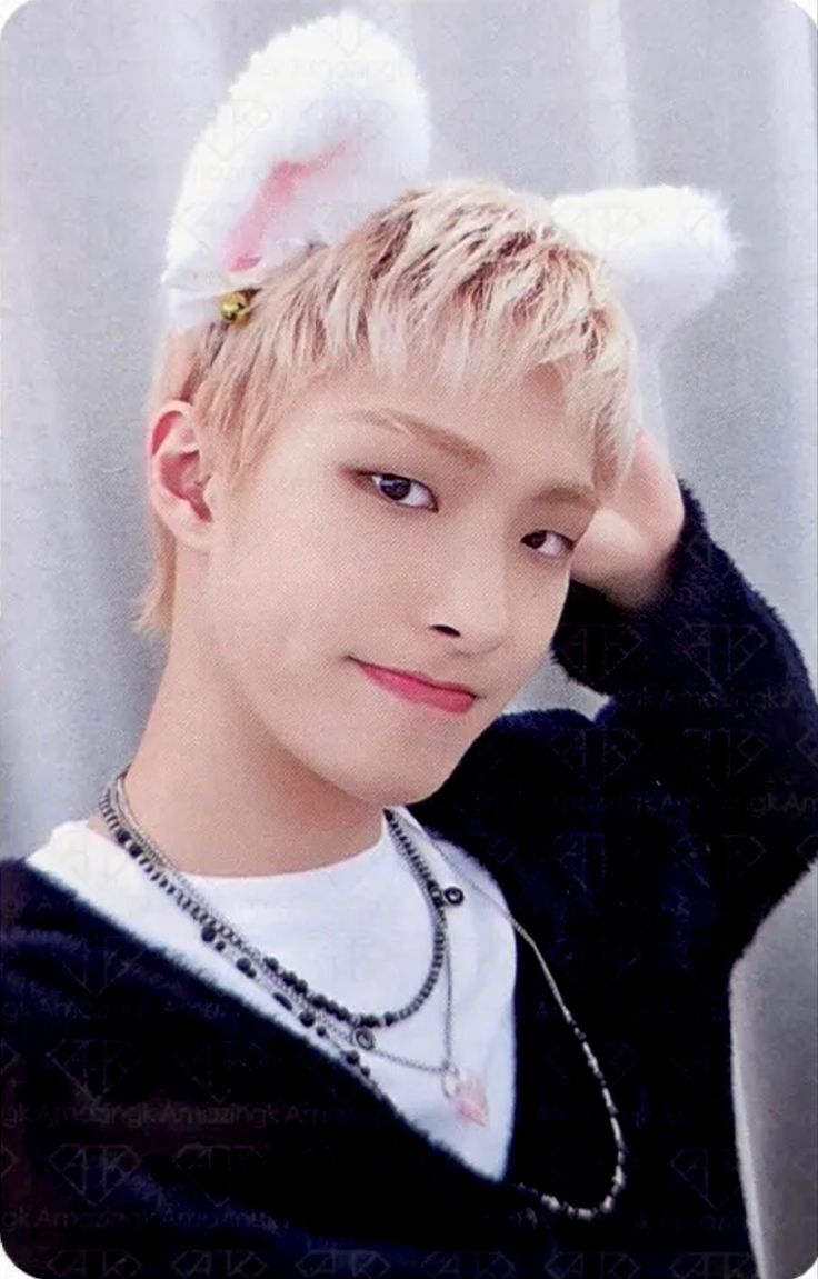 the boy is wearing bunny ears on his head and posing in front of a gray background