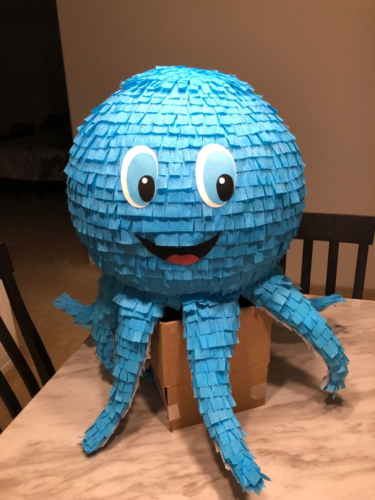 an origami octopus sitting on top of a table next to a cardboard box