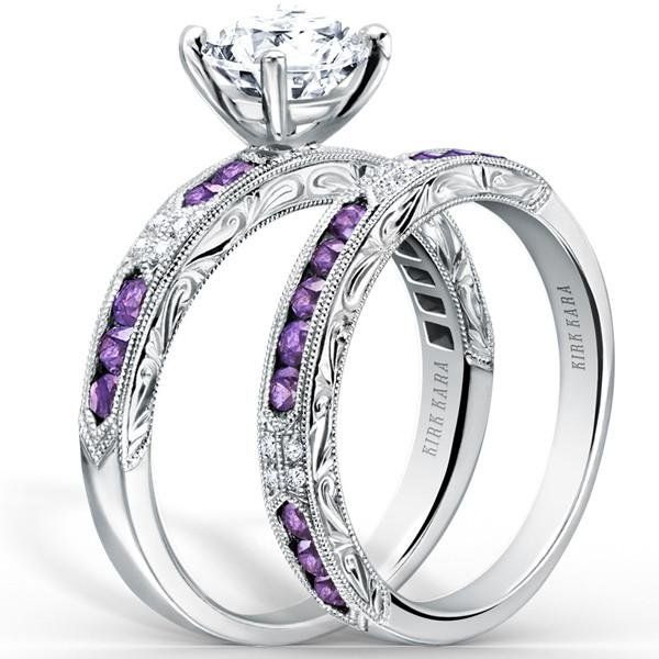 two wedding rings with purple stones on the sides and an intricate band, set in 18k white gold