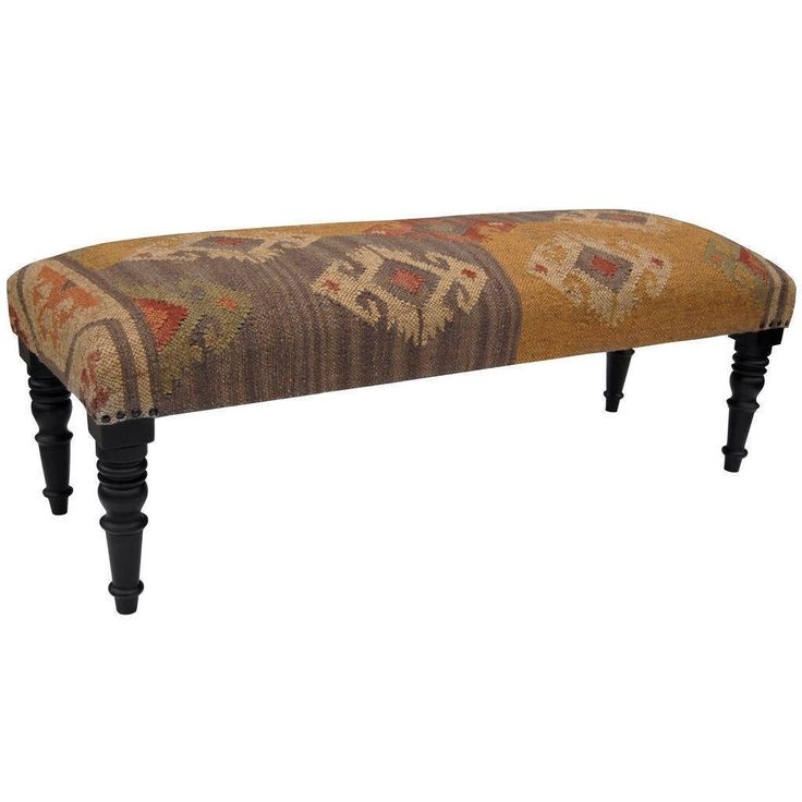 an upholstered bench with wooden legs and a colorful design on the backrest