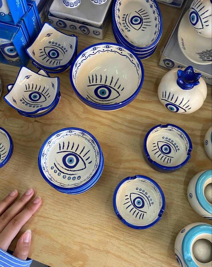 a table topped with lots of blue and white dishes covered in eyeballs on them