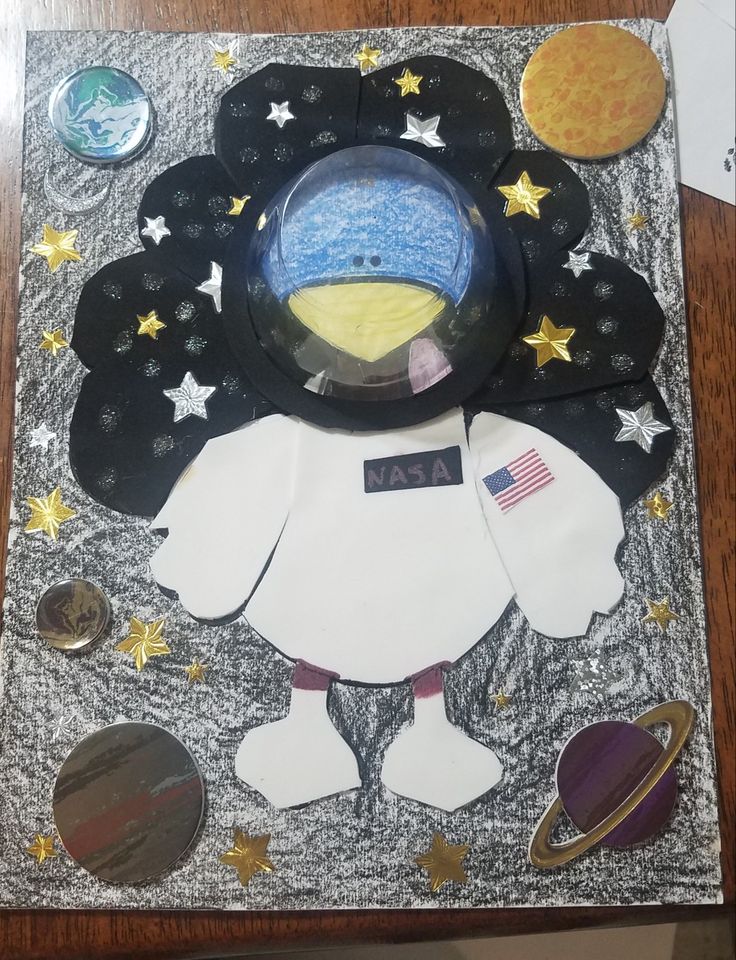 a paper plate with an astronaut's space suit on it, surrounded by other items