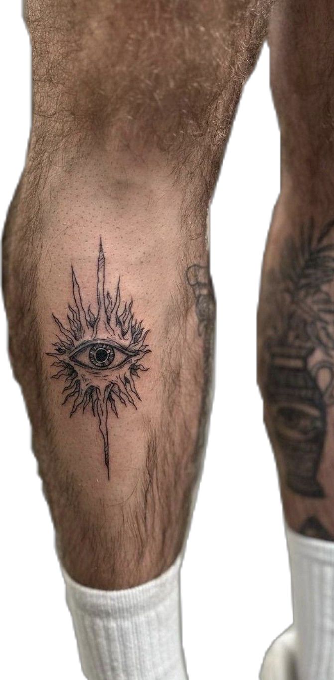 a man's leg with tattoos and an eye on it