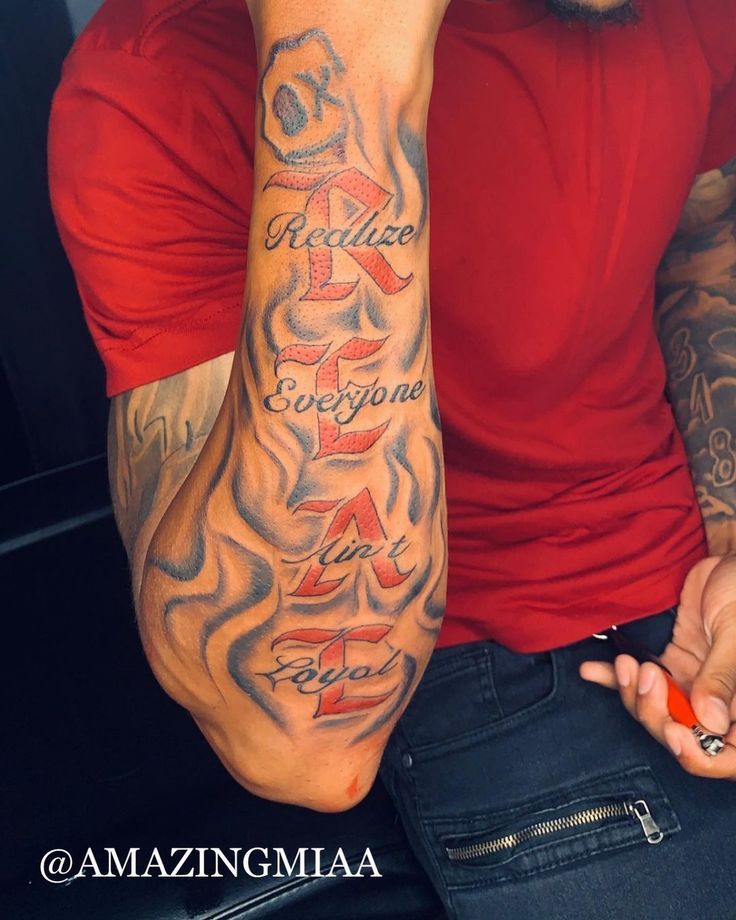 a man with tattoos on his arm and hand