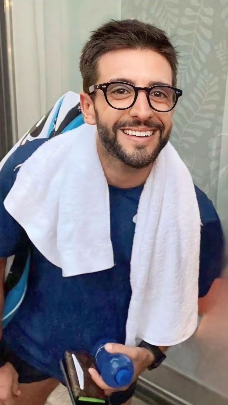 a man with glasses and a towel around his neck