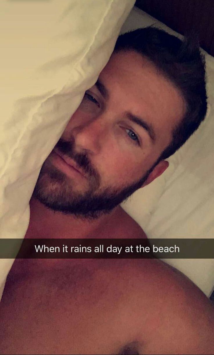 a man laying in bed under a blanket with the caption when it rains all day at the beach