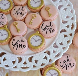 pink and gold decorated cookies sitting on top of a white plate with words written on them