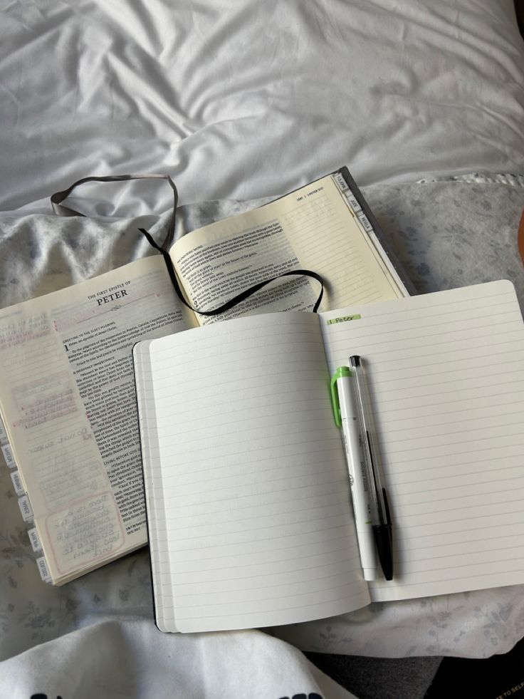 an open notebook and pen on a bed