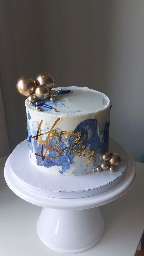 a white cake with blue and gold decorations