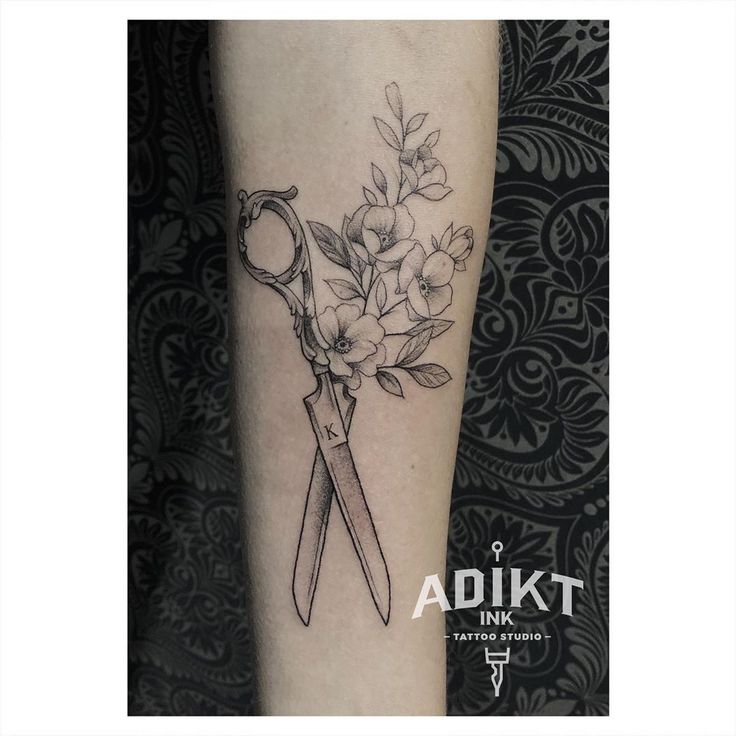 a tattoo with scissors and flowers on the leg, done by adikit ink