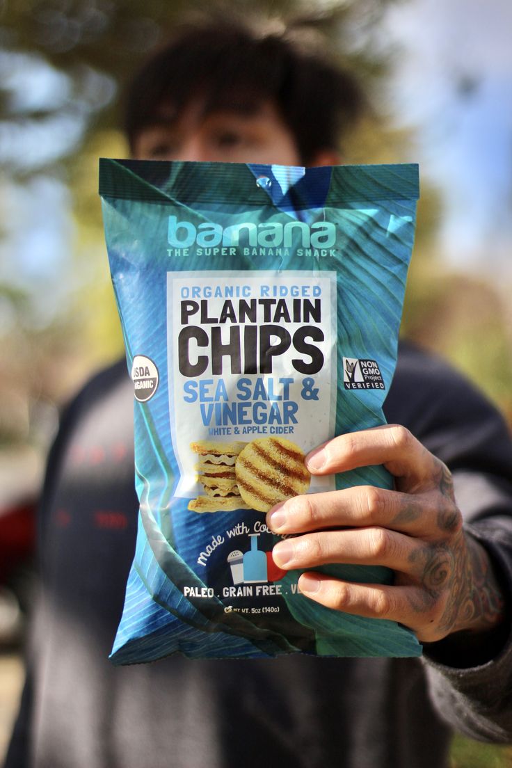 a man holding up a bag of plantain chips