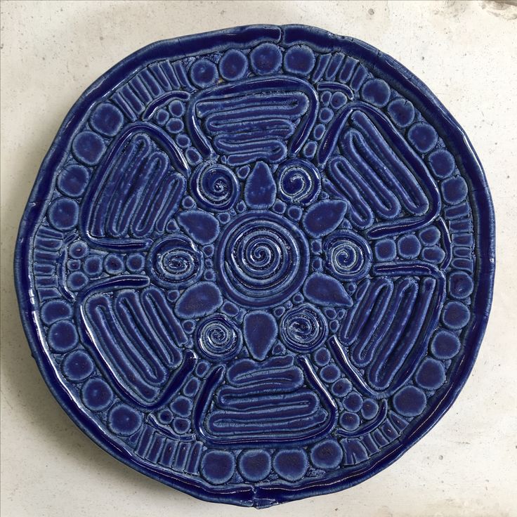 a blue plate sitting on top of a white counter next to a tile wall and floor