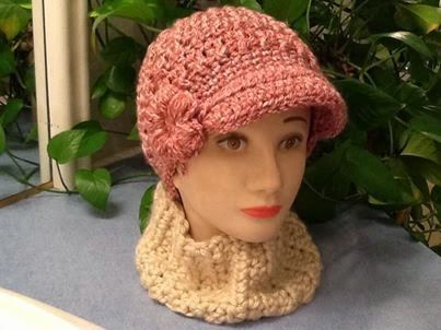 a mannequin head wearing a pink hat and scarf