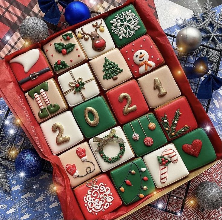 a box filled with christmas themed cookies on top of a table