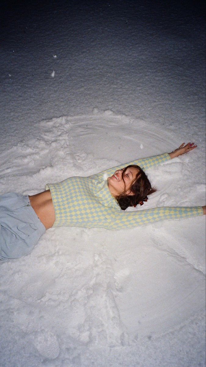 a woman laying in the snow on her stomach