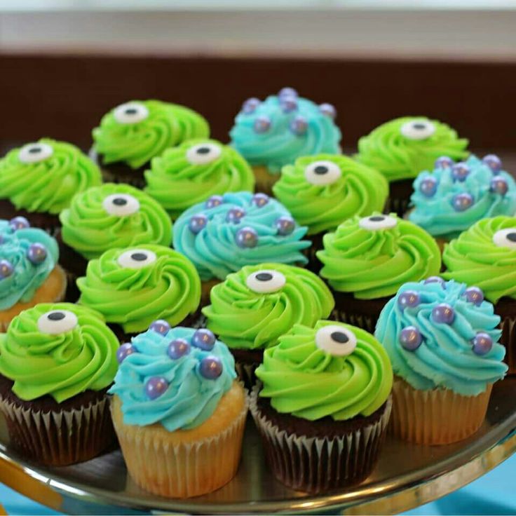 there are cupcakes with green frosting and blue icing on the top