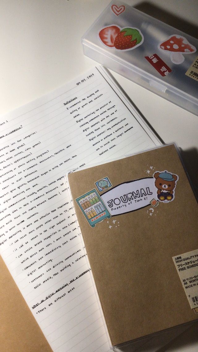 an open notebook sitting on top of a table next to some stickers and papers