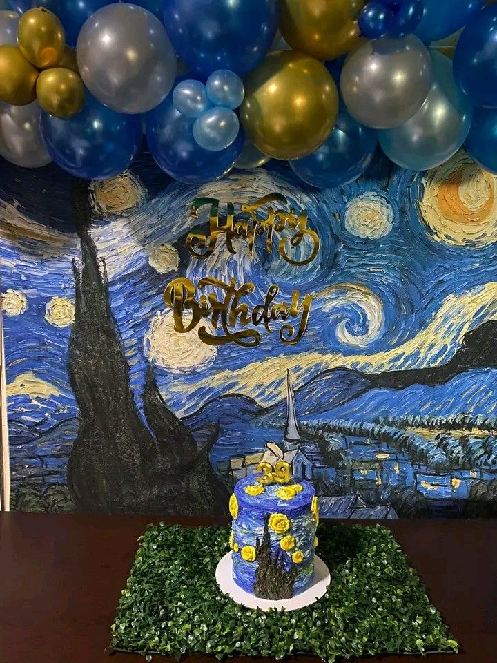 a birthday cake sitting on top of a table next to balloons in the shape of van gogh