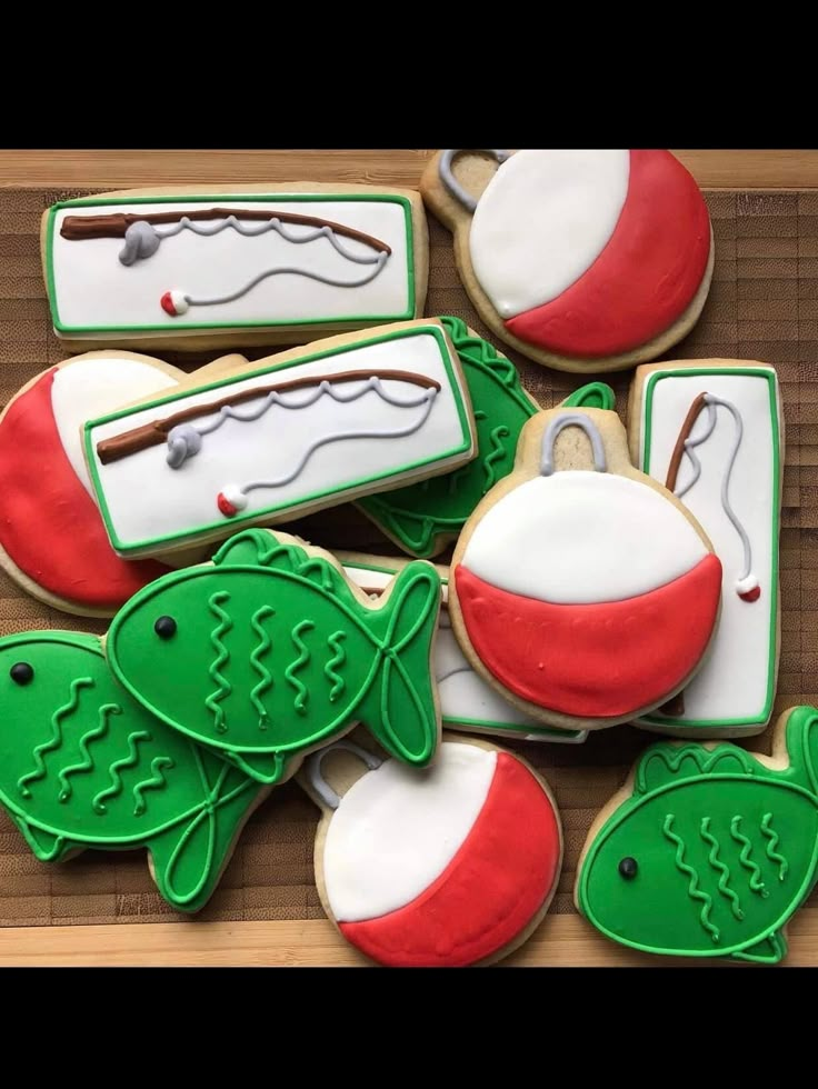 decorated cookies with fishing related items displayed on wooden table top, ready to be eaten