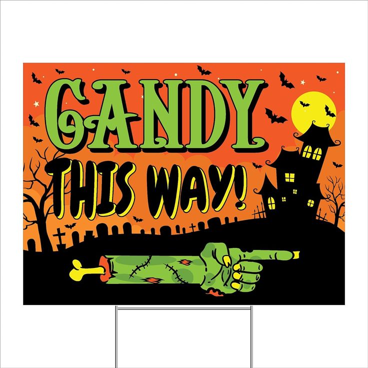 a yard sign that says candy this way with a zombie hand pointing at the viewer