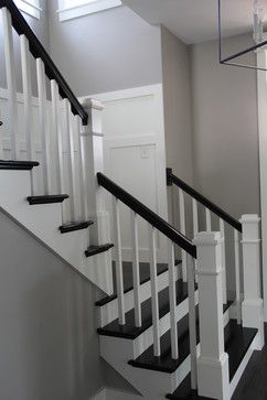 a white staircase with black handrails in a house