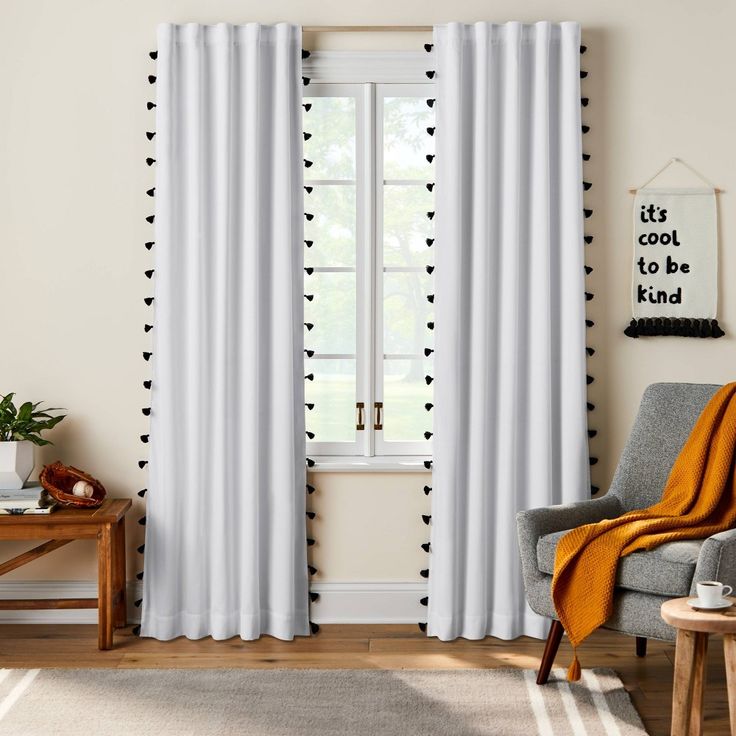 a living room with white curtains and black polka dots