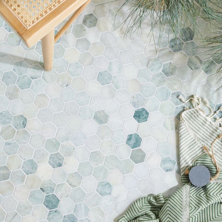 a green and white tiled floor next to a wooden table with a potted plant on it