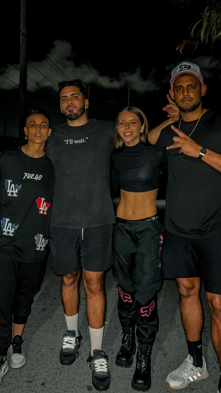 four people posing for the camera at night