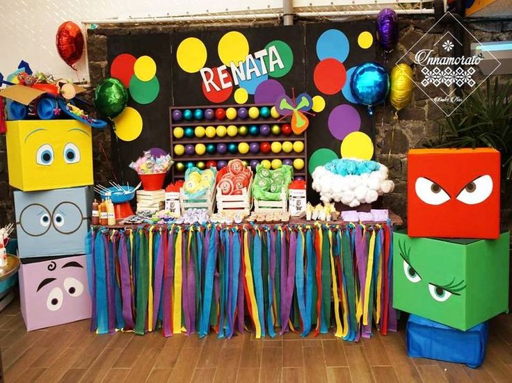 a birthday party with colorful decorations and paper bags on the table for guests to eat