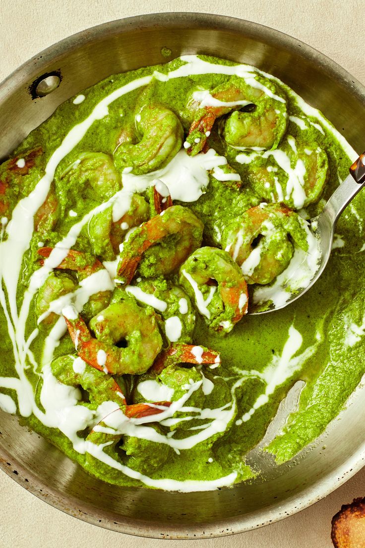 a bowl filled with green sauce and shrimp