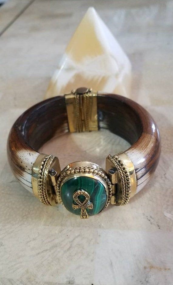 This is it--gorgeous Egyptian-inspired jewelry. This unique horn bone bracelet has a beautiful bronze-plated lead-free pewter ankh pendant on a Malachite crystal stone. It will add a touch of ancient Egypt to your outfit.  The ancient Egyptian symbol is the Ankh. The Ankh is the key to life, the legend of the Nile. It represents the concept of eternal life, which is the general meaning of the symbol.  With the wisdom of the Malachite crystal, progress isn't measured in material riches but in spi Ancient Egypt Jewelry, Egyptian Inspired Jewelry, Egyptian Clothing, Bone Bracelet, Funky Accessories, Egypt Jewelry, Ankh Pendant, Dope Jewelry Accessories, Malachite Crystal