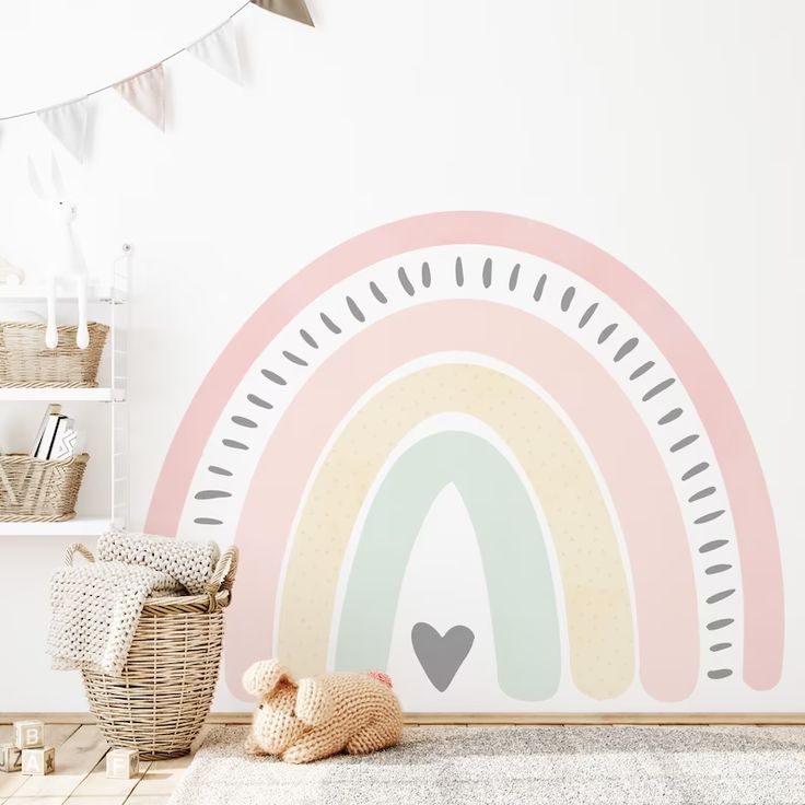 a child's room with a rainbow wall decal in pastel pink and grey